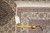 Tape measure and handwritten dealer tag lying on the border at the rug corner