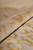 Pile rolled into a fold, silk sheen on gold motifs against the dense wool base