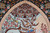 Detail of the brick arch, tiled half dome and two birds among pink blossom