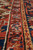 Raking close-up of border pile showing knot rows, gold guard stripe and ivory outlines