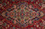 Tight detail of the medallion showing rose, sky blue and olive green flowers on navy ground