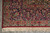 Corner detail of navy border palmettes meeting the ivory guard stripe above trimmed fringe