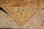 Corner folded back to show the pale knotted reverse, the pattern visible through the foundation