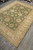 Rug seen lengthwise on grey plank floor with fringe at the near corner
