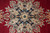 Tight detail of the eight-pointed star medallion with blue rosettes and ivory petal shapes