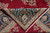 Corner folded back showing navy border cartouches, the knotted back and ivory fringe