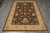 Overhead photograph of the whole rug lying on grey tiled floor, all four borders visible