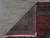 Back of the 10x13 wool rug folded over, showing even hand-knotting and the original tag