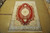 Hand-knotted red and ivory wool area rug laid flat showing the complete Tabriz medallion layout