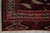 Corner detail with fringe, elem panel, ivory hooked border motifs and deep burgundy tribal field