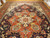 Central coral medallion detail on navy ground, sage green and gold rosettes, oversized wool rug
