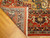 Back of the hand-knotted wool rug folded to show knot rows, fringe and coral border
