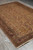 Full length angled photograph of the 7x10 wool rug displayed flat on a tiled studio floor