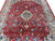 Red field with scrolling vines, blue rosettes and ivory diamond medallion seen from one corner
