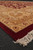 Corner of the oversize red and gold Oriental rug with thick ivory cotton fringe outdoors