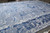 Angled floor view showing silk sheen and abstract blue pattern across this mansion size area rug