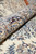 Rolled edge of the Nain rug revealing pile thickness, silk highlights and burgundy border blossoms