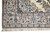 Corner with hand-knotted ivory fringe, layered guard borders and light blue floral scrollwork