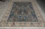 7 x 10 midnight blue Nain rug displayed flat on grey floor showing complete tree design