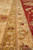 Sage green guard stripe beside the coral main border showing fine hand-knotted wool detail