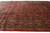 Angled view showing the navy floral border and dense red field of this palace size rug