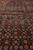 Macro detail of the Herati fish pattern, tiny rosettes and diamond lattice on black wool pile