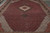 Ruby red field and ivory stepped medallion of this 12' x 18'6" hand-knotted oversize rug