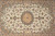 Close view of the central medallion surrounded by curling black arabesques and pastel palmettes on ivory