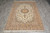 5'5" x 7'7" Persian Isfahan rug photographed on grey tile floor showing medallion, border and fringe