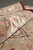 Rolled edge detail showing thick wool and silk pile with pink and green floral border