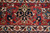 Red main border detail with navy and gold cartouche motif framed by ivory guard bands