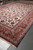 Large ivory and red Persian Isfahan rug shown full length in the Freeport warehouse