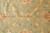 Close up of hand-knotted wool pile showing gold palmettes and fine red outlining on green