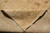 Folded corner revealing tight hand-knotted back, cotton foundation and ivory fringe of the wool rug