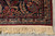 Corner detail with navy border, red rosettes, camel vine and hand-tied ivory fringe