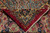 Back of the rug folded to show tight hand-knotted weave, wool pile and ivory fringe