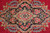 Navy central medallion filled with pink cabbage roses and turquoise blossoms on red wool ground