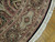 Border detail showing pale green cartouches, burgundy scrollwork and hand-tied ivory fringe along the round edge