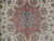 Close-up of peach and grey blue central medallion surrounded by fine floral tracery on ivory