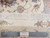 Ruler held against ivory fringe end showing hand-knotted 70 Raj weave and cotton foundation