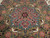 Close-up of teal and rust medallion with woven peacocks, shot under warm light showing olive ground