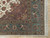 Corner detail of teal blue border with cranes, deer and floral vines beside ivory fringe