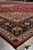 Low angle along the red Tabriz rug showing spandrel, layered borders and fringe end