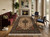 Living room with burgundy sofa, fireplace and ivory Tabriz wool and silk area rug