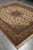 Whole 8' x 9'7" Persian Tabriz rug angled on concrete showing medallion and fringe