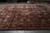 Burgundy oversize Kerman rug laid flat in warehouse showing all over floral field and salmon border