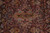 Detail of the small central floral medallion in salmon, olive green and blue on burgundy