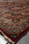 Low angle along the border showing rose medallions, blue florals and deep burgundy selvedge edge