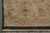 Corner of beige main border with clover motif, dark green outer band and fringe
