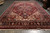11'7" x 18'2" wool rug viewed lengthwise with ivory fringe and wide red outer band